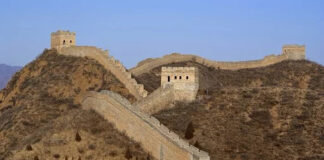 Mura di fortificazione intervallate da torri si inerpicano lungo un promontorio