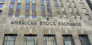 The photo shows the American Stock Exchange Building, a grey Art Decò palace with several windows and a US flag at the center