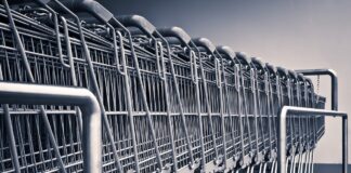 foto in scala di grigi di un fila di carrelli del supermercato