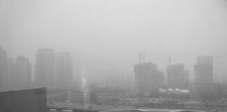 black and white photo of a city enveloped in fog