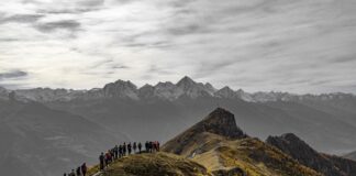 su un sentiero di montagna un gruppo di persone cammina in fila indiana